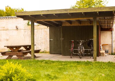 Overdækket terrasse med bord og cykler på HabitusHuset Sigerslevvej.