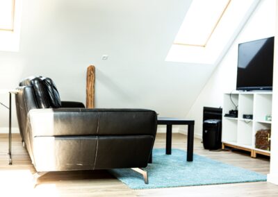 Sort sofa i stueområde med ovenlys på HabitusHuset Sigerslevvej.